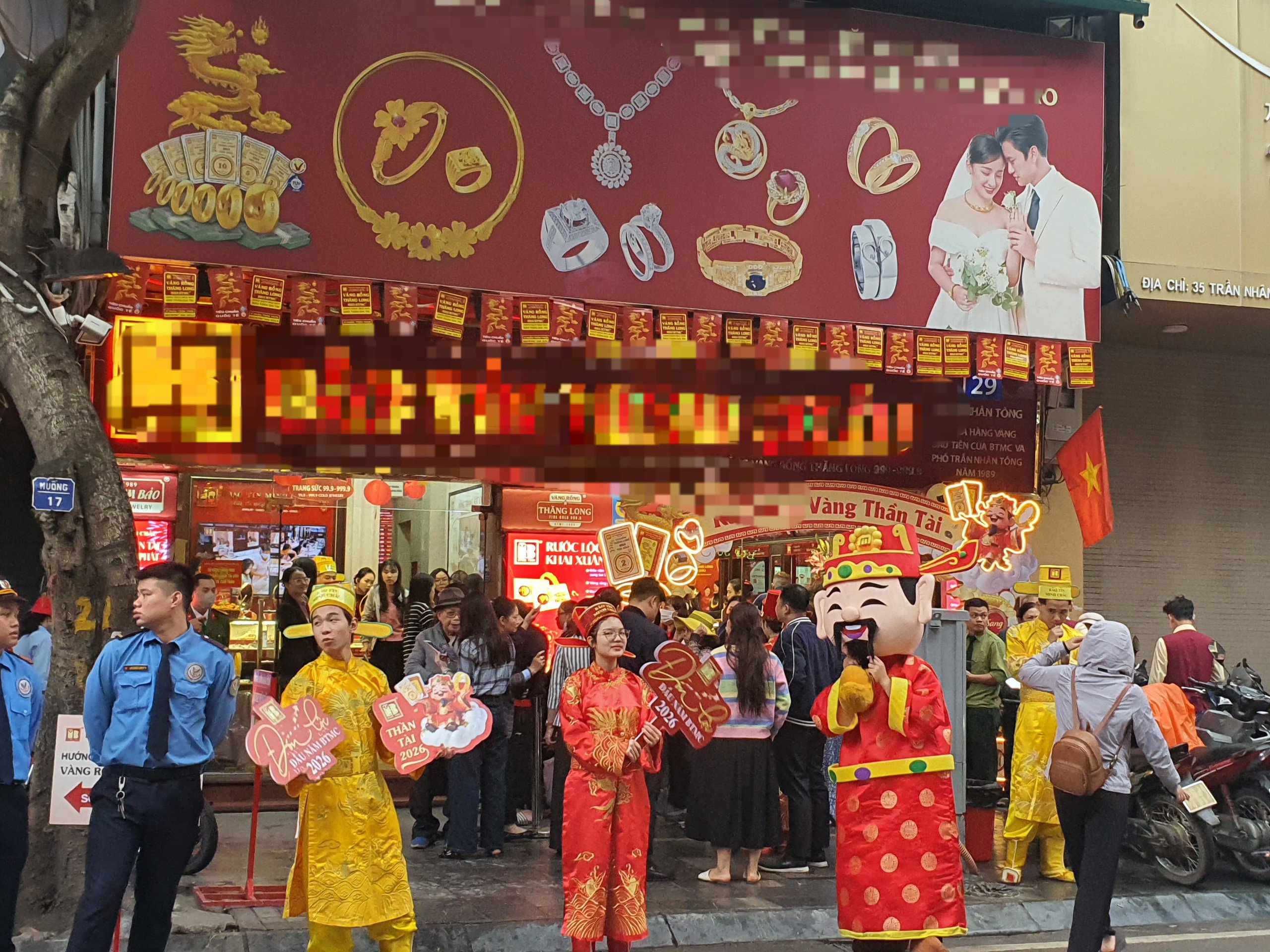 Bên ngoài, hàng chục nhân viên các cửa hàng vàng mặc quần áo vàng và đỏ đóng giả ông Thần Tài, tay cầm thỏi vàng đứng ngoài cửa vẫy chào khách.