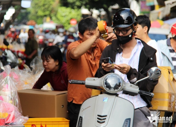 Đức (27 tuổi) chọn mua loại bánh may mắn kích thước lớn nên phải nhờ nhân viên sạp hàng đóng hộp. Ảnh: Hà Nguyễn