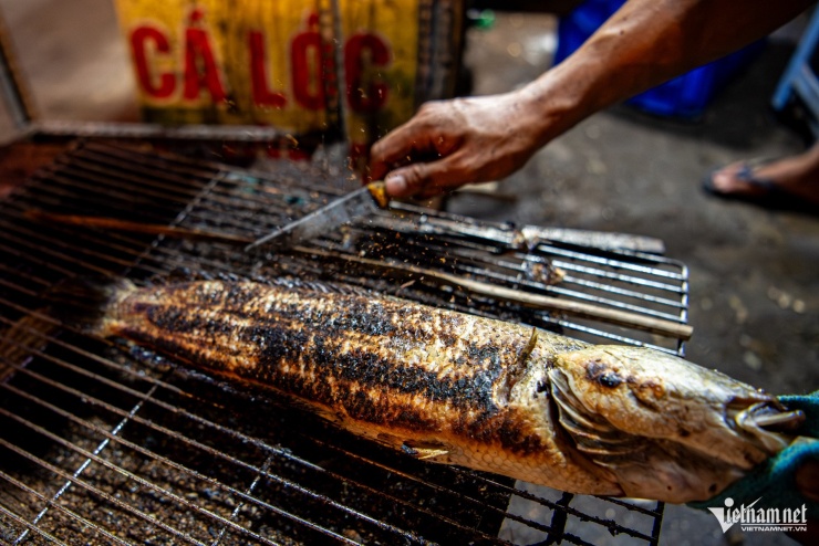 Người nướng cá liên tục trở tay, gõ nhẹ để loại bỏ lớp vảy và phần da cháy khét bên ngoài, giữ lại phần thịt bên trong chín vàng, thơm và không bị ám vị đắng. Họ thường dùng một thanh tre hoặc khúc gỗ đập nhẹ lên thân cá để vảy và tro than bong ra dễ dàng, nhờ đó việc cạo sạch lớp cháy xém sau khi nướng diễn ra nhanh gọn hơn.