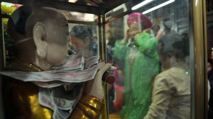 Cảnh người dân dúi tiền vào tượng Phật gây phản cảm nhiều năm trước.