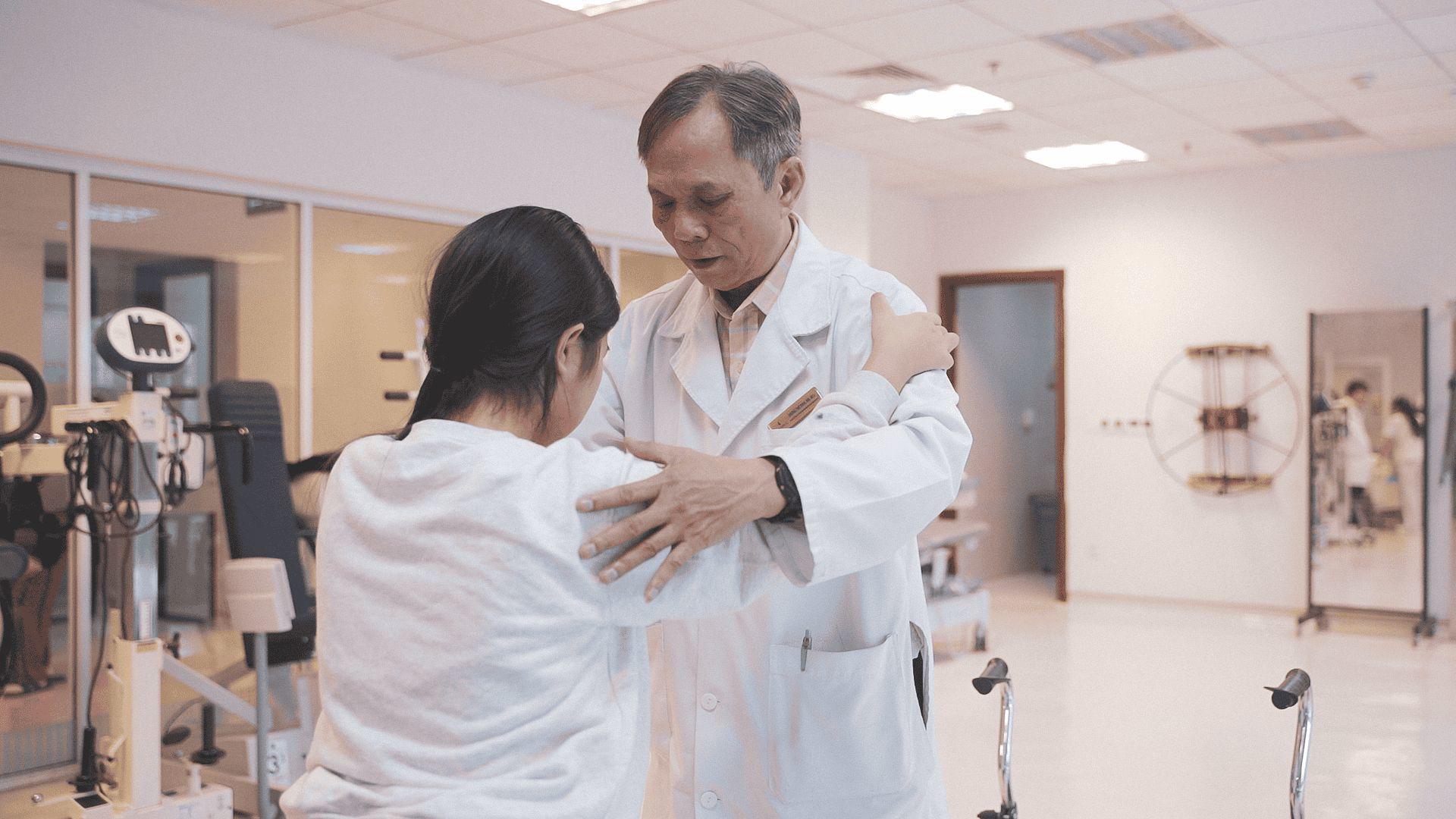 M. chập chững tập đi dưới sự hướng dẫn của bác sĩ phục hồi chức năng.