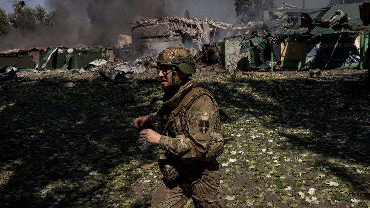 Một binh sĩ Ukraine chạy ngang qua địa điểm - nơi một quả bom lượn của Nga phát nổ vài phút trước đó, gây hư hại cho các tòa nhà trong khu vực gần thành phố Pokrovsk vào tháng 9/2025. Ảnh The New York Times.