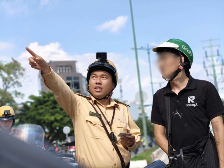 Cán bộ CSGT chỉ biển báo cấm cho người vi phạm thấy.