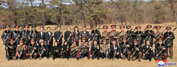 Ông Kim Jong-un và con gái chụp ảnh cùng các quan chức được tặng súng. Ảnh: KCNA
