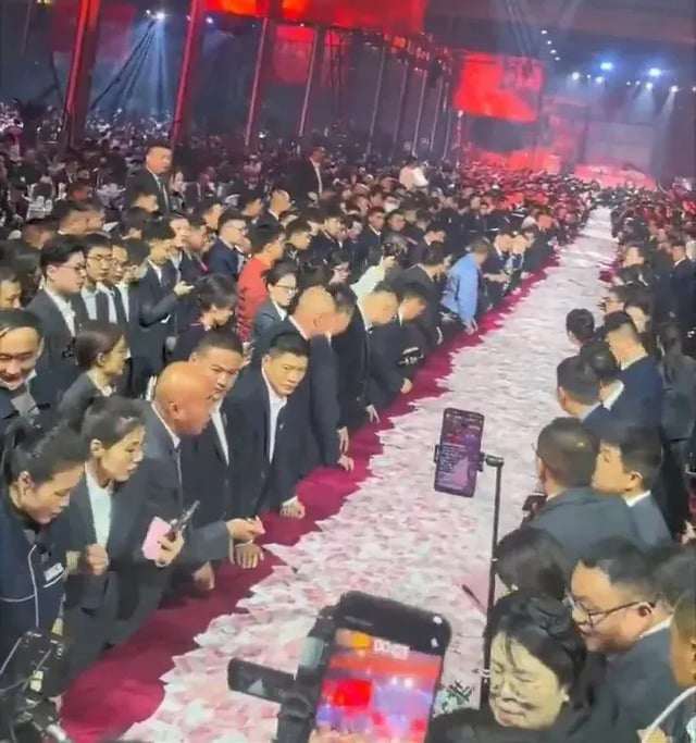 Hàng ngàn nhân viên xếp hàng dọc theo những bàn tiệc trải đầy tiền mặt. Ảnh: X