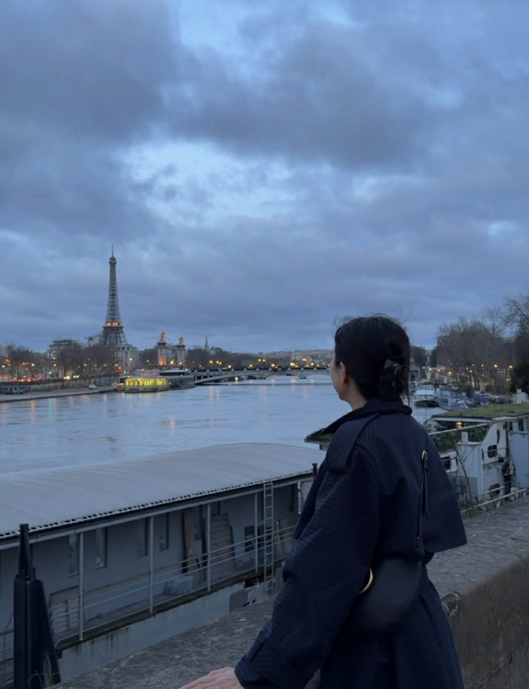 Bà mẹ ba con dạo bộ dọc theo sông Seine, ngắm thành phố Paris lúc trời vừa hửng sáng, khi đèn đường vẫn còn rọi vàng trên mặt nước.