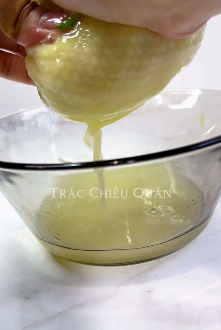 Thêm 1/4 bát nước vào chung, sau đó cho gừng vào màng lọc, bóp chặt để lọc nước cốt gừng ra.