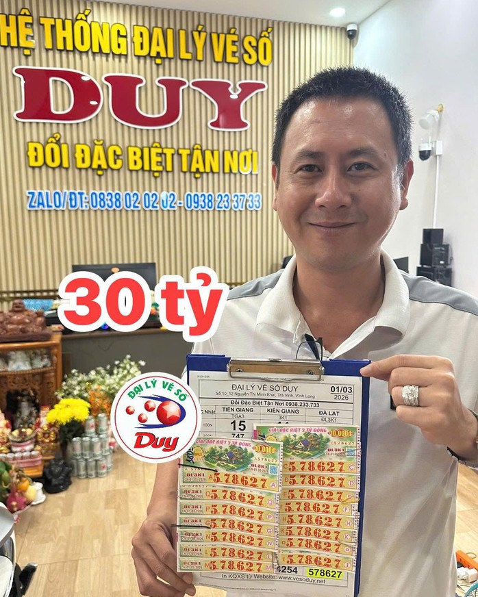 Đại lý vé số Duy đổi thưởng cho nữ khách hàng trúng độc đắc 30 tỉ đồng. Ảnh: ĐLVS Duy