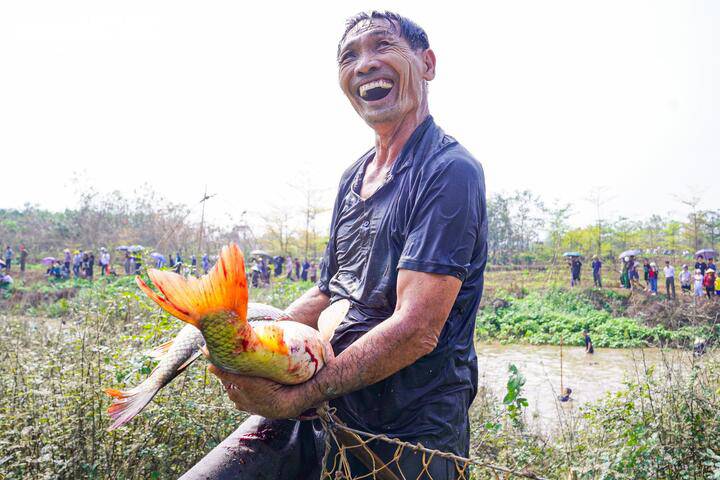 Cầm trên tay những con cá lớn vừa bắt được, người dân tiến về Đền Ngo để bàn giao cho ban tổ chức, chuẩn bị nghi lễ dâng thánh diễn ra ngày 15 tháng Giêng tại đình Tường Phiêu.