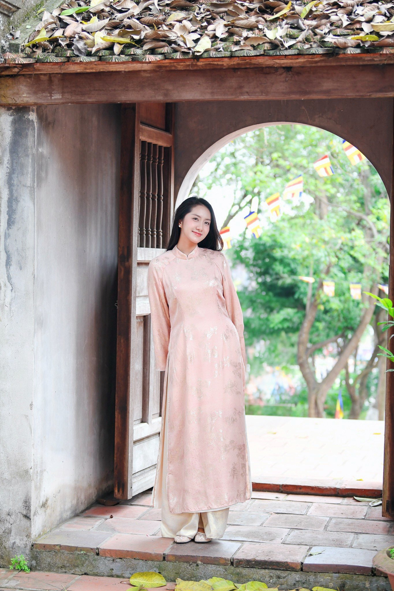 Cô kết hợp quần lụa đồng điệu tạo tổng thể pastel trang nhã. Trang phục góp phần tôn lên vẻ nền nã của Hoa hậu Hà Trúc Linh trong hành trình du xuân miền di sản.