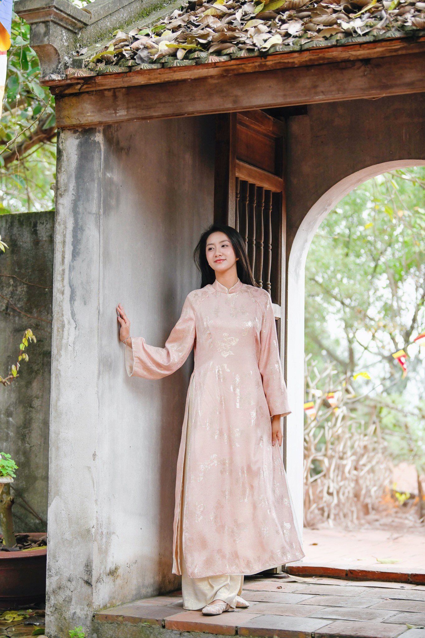 Cô kết hợp quần lụa đồng điệu tạo tổng thể pastel trang nhã. Trang phục góp phần tôn lên vẻ nền nã của Hoa hậu Hà Trúc Linh trong hành trình du xuân miền di sản.