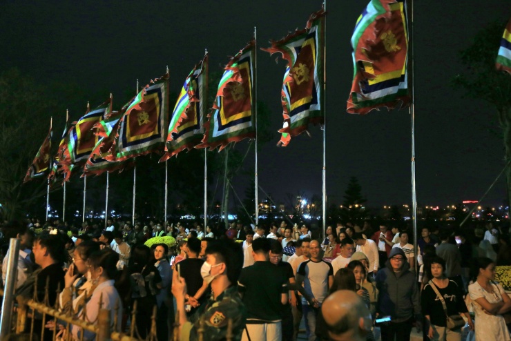 Phía bên ngoài khu vực nội tự, người dân đứng kín sau hàng rào sắt, chăm chú theo dõi từng nghi thức.