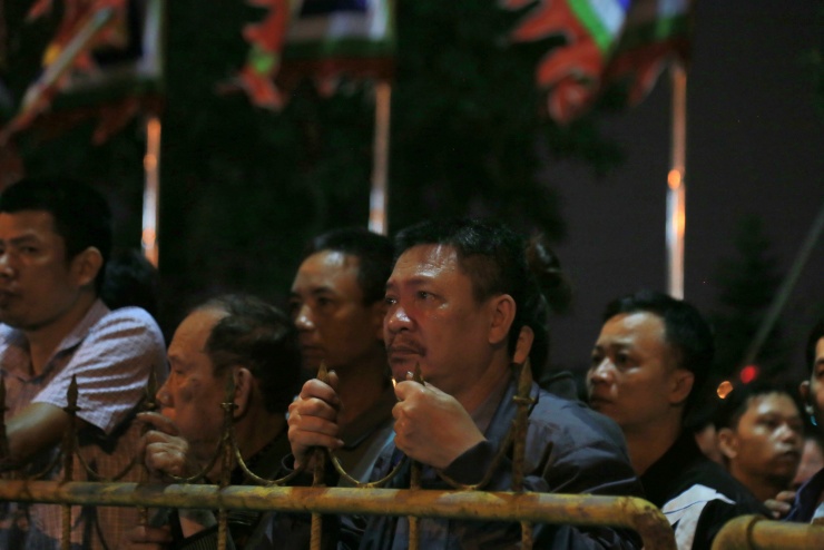 Đến khoảng 23h, khu vực bên ngoài đền, phía ngoài rào sắt, hàng nghìn người tiếp tục xếp hàng dài chờ đợi. Nhiều người bám sát hàng rào, ánh mắt hướng vào bên trong với hy vọng sớm được vào hành lễ.