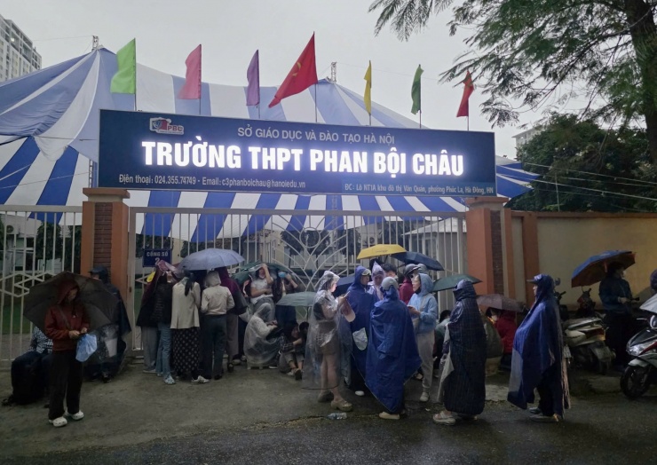 Phụ huynh trú mưa ở mái hiên đối diện trường, 6h sáng lúc 3/3. Ảnh Thanh Hằng&nbsp;