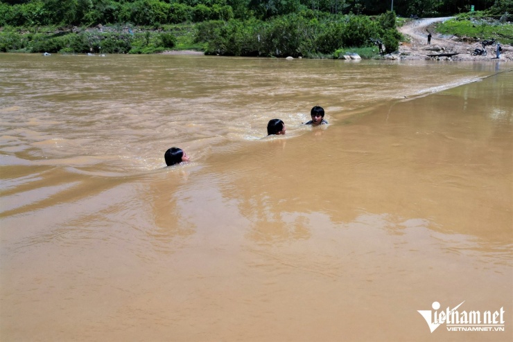 Khi bè ở bờ bên kia, nhiều học sinh phải bám dây cáp bơi qua sông để kịp giờ đến trường.
