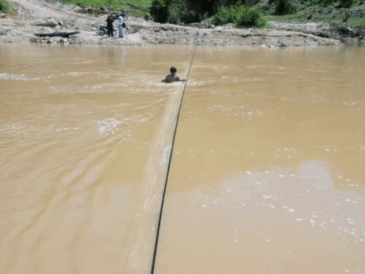 Cầu treo chậm tiến độ, người dân liều mình qua sông bằng bè tự chế