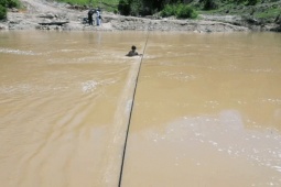 Cầu treo chậm tiến độ, người dân liều mình qua sông bằng bè tự chế