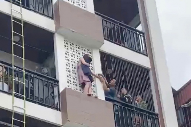 Cô gái trèo ra ngoài tầng cao ngôi nhà.