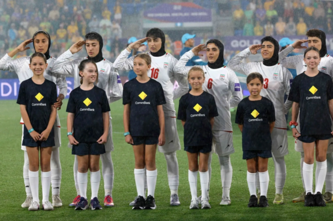 Các cầu thủ Iran hát quốc ca và chào cờ trước trận thua Australia 0-4 ở lượt hai bảng A Asian Cup nữ 2026, trên sân Gold Coast ở Australia ngày 5/3/2026. Ảnh: AFP