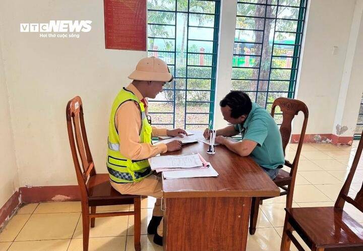 Cán bộ CSGT lập biên bản vi phạm hành chính với tài xế N.D.D. (Ảnh: CA)