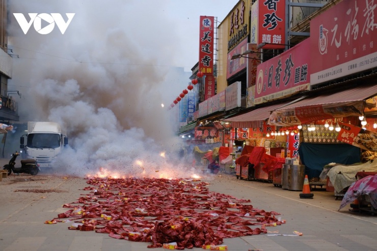 Khi đoàn rước đi qua, pháo được châm lửa đồng loạt, tạo nên những tràng nổ giòn vang và khói đỏ phủ kín không gian.