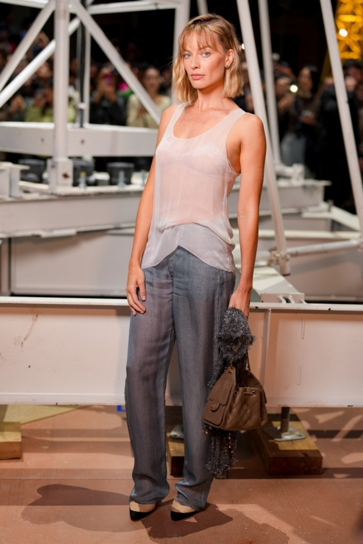 Margot Robbie gây ấn tượng với mái tóc lob, bộ đồ lụa tối giản gồm áo tank top xuyên thấu, quần ống đứng.