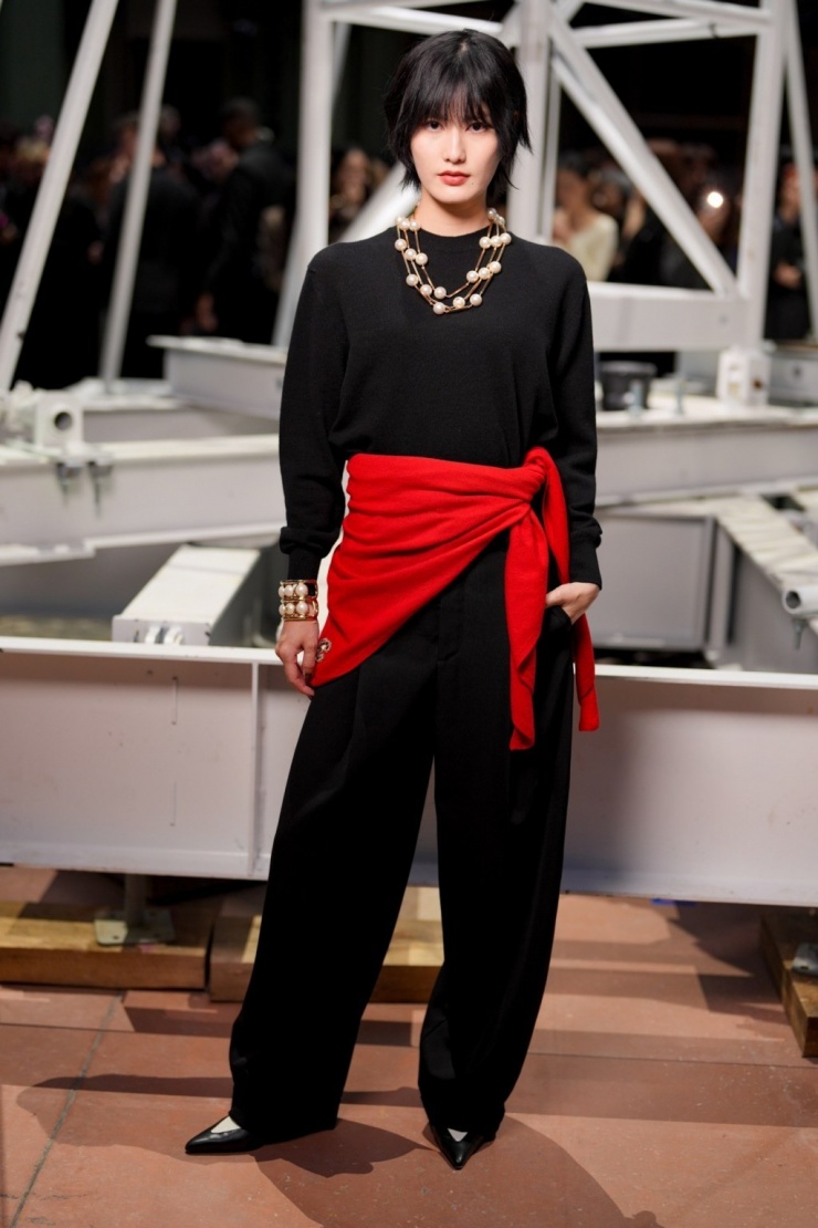 Diễn viên Nhật Bản Ai Hashimoto dùng áo len đỏ buộc ngang eo làm điểm nhấn cho bộ đồ đen.