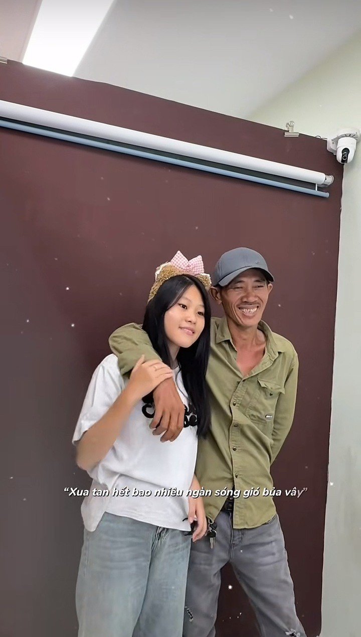 Người cha vui vẻ chiều theo yêu cầu chụp ảnh của con gái. (Ảnh: Chụp màn hình)