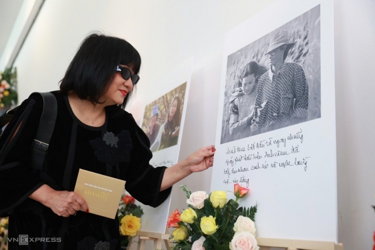 Ca sĩ Cẩm Vân ngắm những bức ảnh tư liệu về hai tên tuổi huyền thoại nhạc Việt, được trưng bày trong buổi giao lưu, ký tặng sách của Khánh Ly, hôm 8/3 tại TP HCM.
