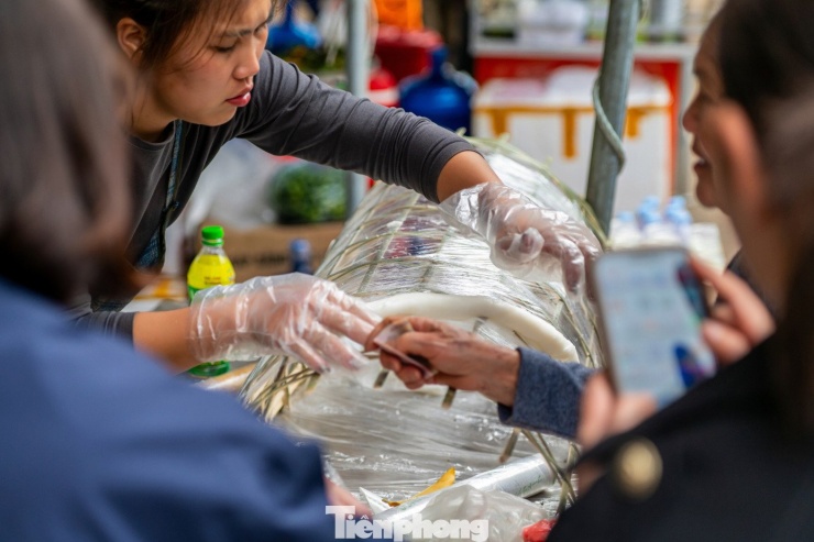 Bánh sau khi chín sẽ dùng ống tre khéo léo lột miếng bánh nóng hổi lên một chiếc phên bằng tre được bọc túi bóng kính xung quanh. Khi bánh còn nóng người làm bánh sẽ khéo léo cuộn bánh thành hình tròn.
