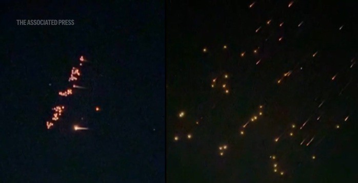 Ảnh cắt từ video của AP cho thấy những quả bom nhỏ từ vũ khí chùm của Iran đang bung ra trên bầu trời Israel - Ảnh: AP