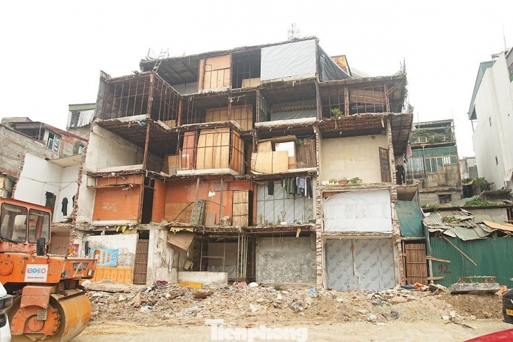 Dãy nhà bị cắt gọt nham nhở, được gia cố tạm bằng khung sắt, tiềm ẩn nguy cơ mất an toàn.