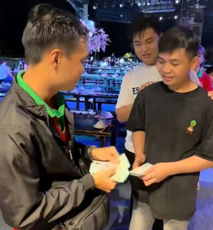 Anh phát tặng tiền cho nhiều người trong quán. Ảnh cắt ra từ clip
