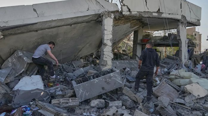 Người dân kiểm tra ngôi nhà bị Israel không kích khiến nhiều người trong một gia đình thiệt mạng tại làng Erkay, miền Nam Lebanon ngày 12-3. Ảnh: AP