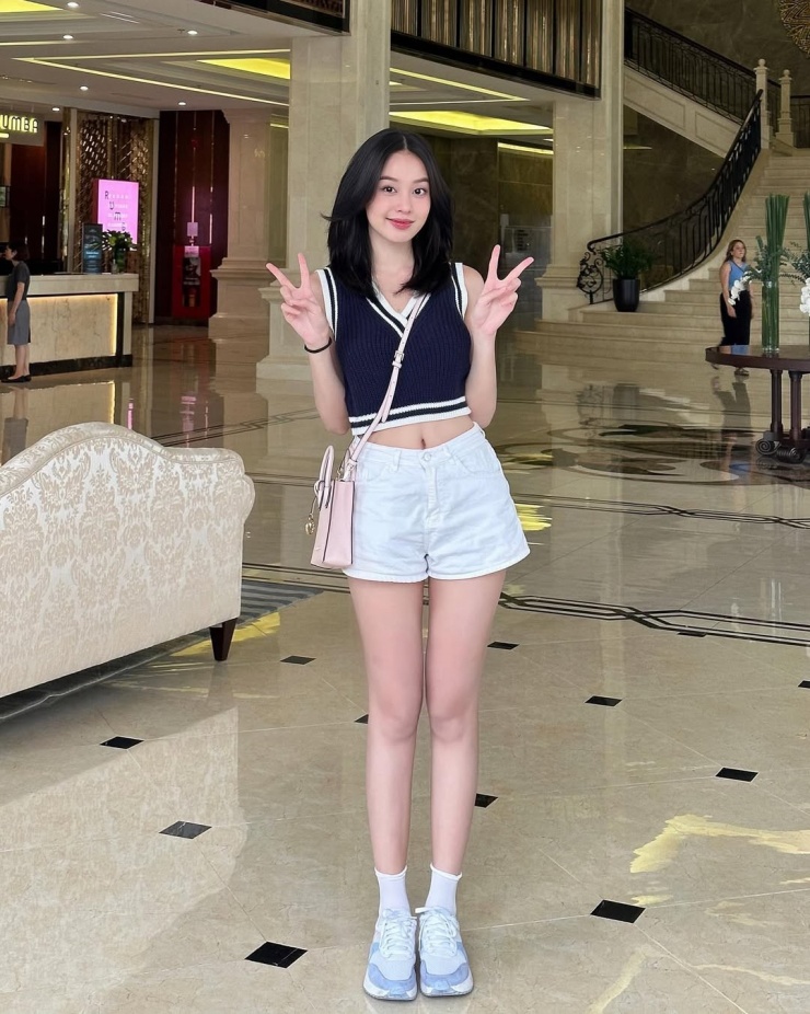 Thanh Thủy kết hợp gilet dệt kim, quần shorts và giày thể thao khi đi du lịch.