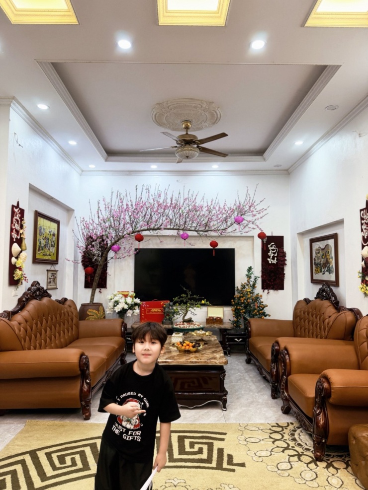 Phòng khách sử dụng gam trắng làm chủ đạo, kết hợp hệ thống đèn trần và quạt hiện đại. Đây cũng là không gian sinh hoạt chung, nơi Hòa Minzy và chồng con thường chụp ảnh.