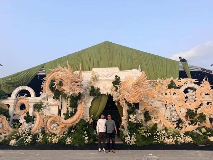 Đức Huy (trái) và một người bạn chụp ảnh kỷ niệm trước rạp cưới của anh.