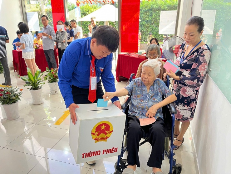 Các bạn đoàn viên thanh niên mang thùng phiếu đến vị trí thuận tiện để người cao tuổi bỏ phiếu. Ảnh: Thùy My