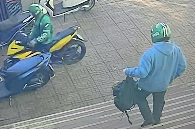 Nghi phạm cầm túi tiền đi ra xe máy của đồng phạm chờ sẵn. Ảnh cắt từ video