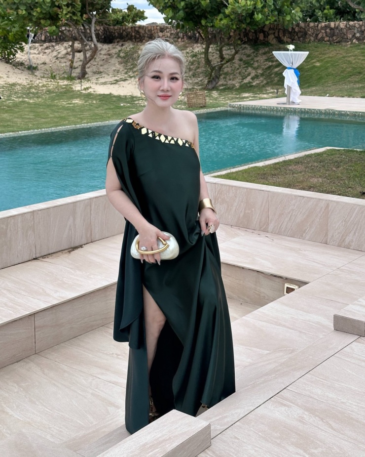 Người đẹp tôn sắc vóc tuổi ngũ tuần với chiếc đầm lệch vai có điểm nhấn metallic khi đi ăn cưới.