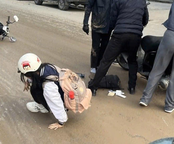 Một em học sinh ngã ra đường, sáng 16/3. Ảnh: Bùi Thủy