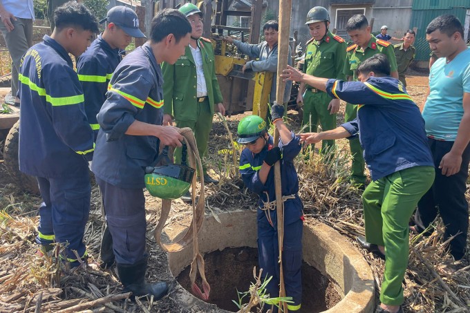 Cảnh sát đu dậy xuống giếng cứu đứa bé. Ảnh: Ngọc Oanh