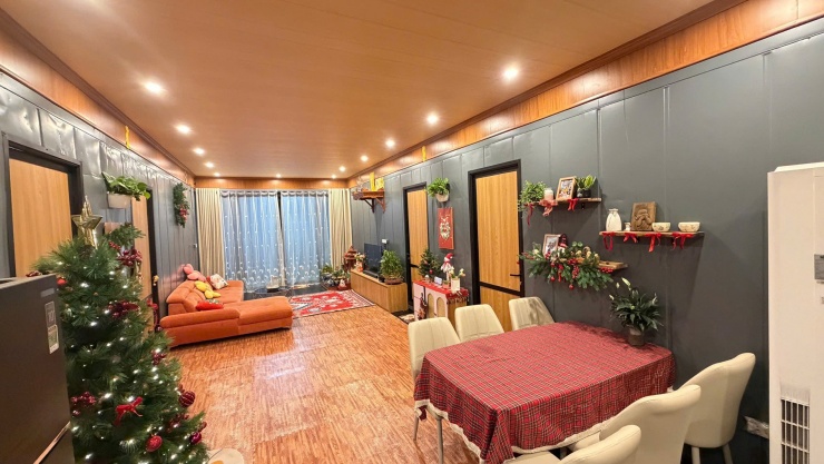 Không gian phòng khách thông với bếp. Gia chủ sử dụng một lớp ván gỗ công nghiệp để lót sàn