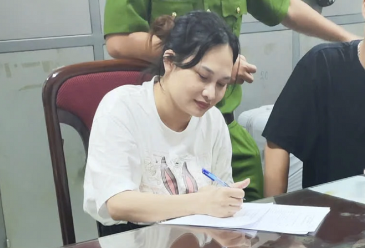 Cảnh sát làm thủ tục bắt giữ Ngô Thị Thêu sau khi dẫn giải cô ta từ Thái Lan về nước. Ảnh: Bộ Công an.