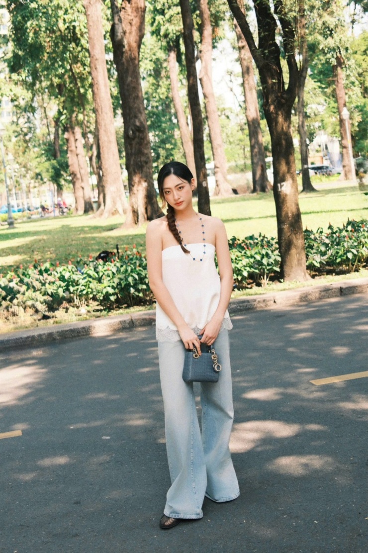 Người đẹp theo đuổi xu hướng ‘đồ ngủ xuống phố’ với áo bandeau satin phối ren từ nhà mốt Zara. Cô phối cùng quần jeans sáng màu và giày lưới đế thấp dạo phố cùng bạn bè.