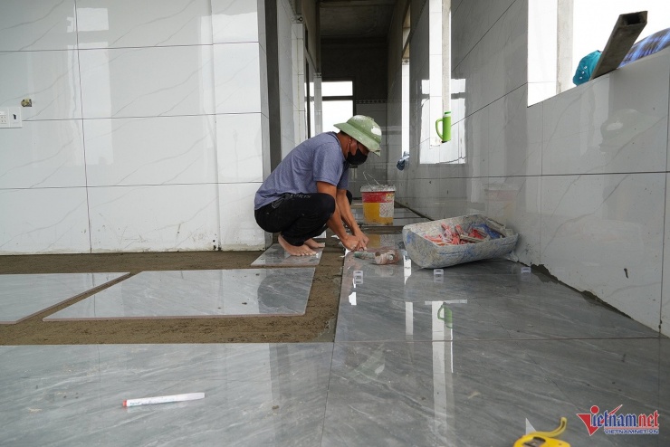 Đội thợ thi công lát gạch tại tầng 3 căn nhà