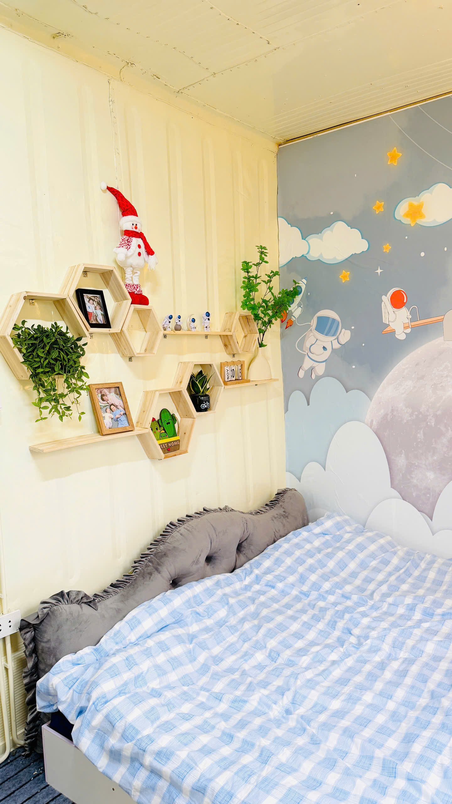 Phần tường được giữ nguyên bản từ container. Chị Linh dán giấy, tranh và gắn thêm kệ gỗ để tăng tính thẩm mỹ cho không gian sống