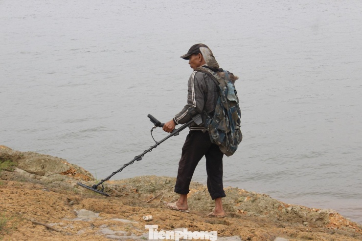 Tranh thủ nước sông cạn người dân mang máy dò kim loại quý.