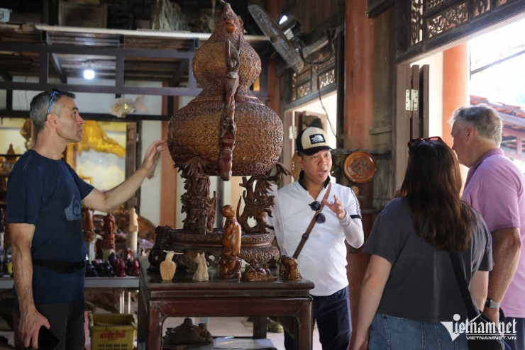 Du khách thích thú chiêm ngưỡng tác phẩm "Nguồn cội" đạt giải ba trong cuộc thi sản phẩm thủ công Việt Nam năm 2010.