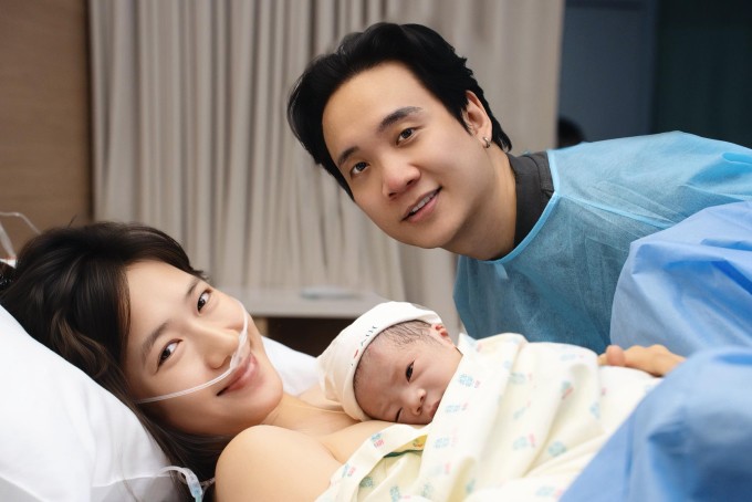 JustaTee bên bà xã Trâm Anh và con thứ ba.